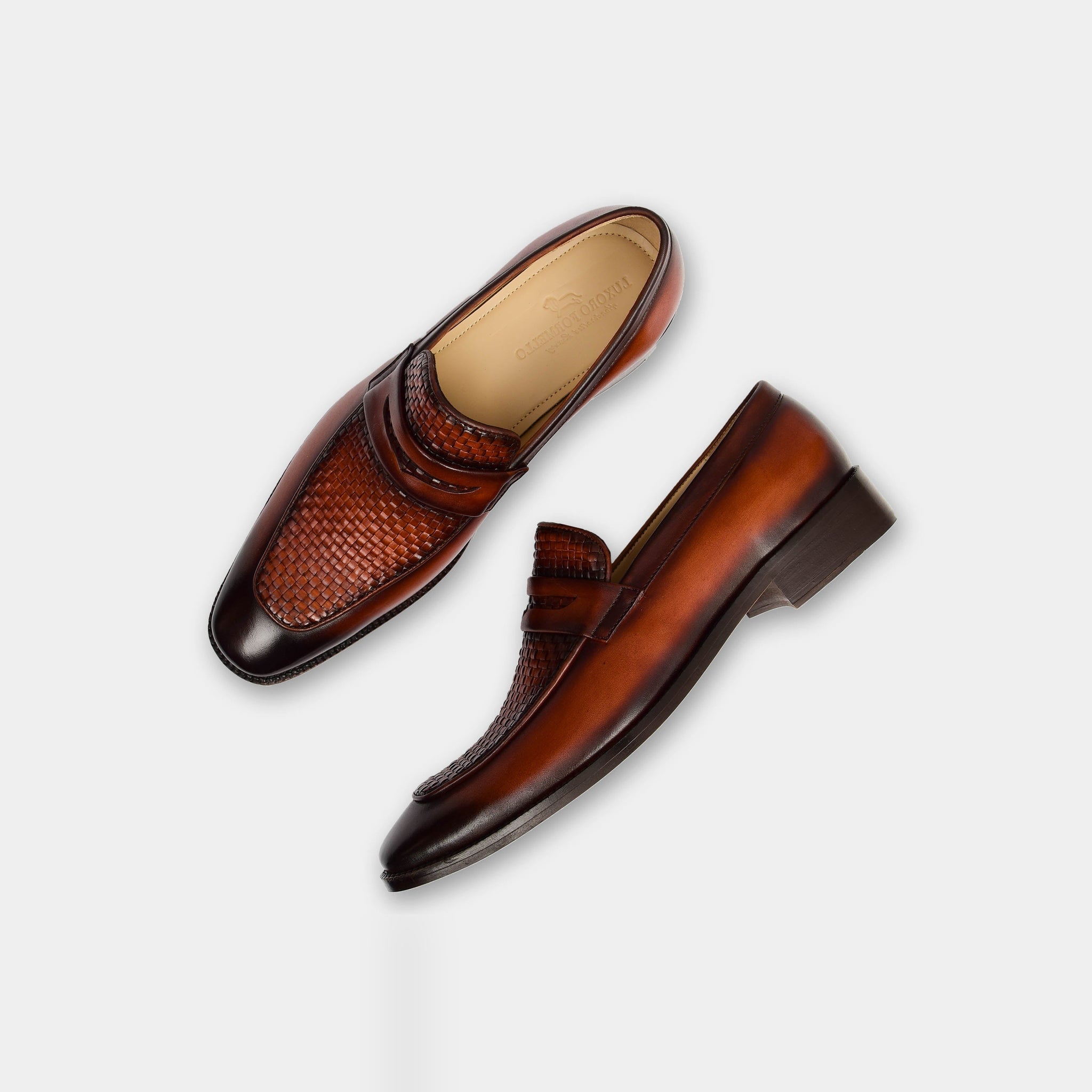 Pair of The Harold Leather Loafers in brown, featuring a woven leather detail on the toe and a classic penny loafer strap.