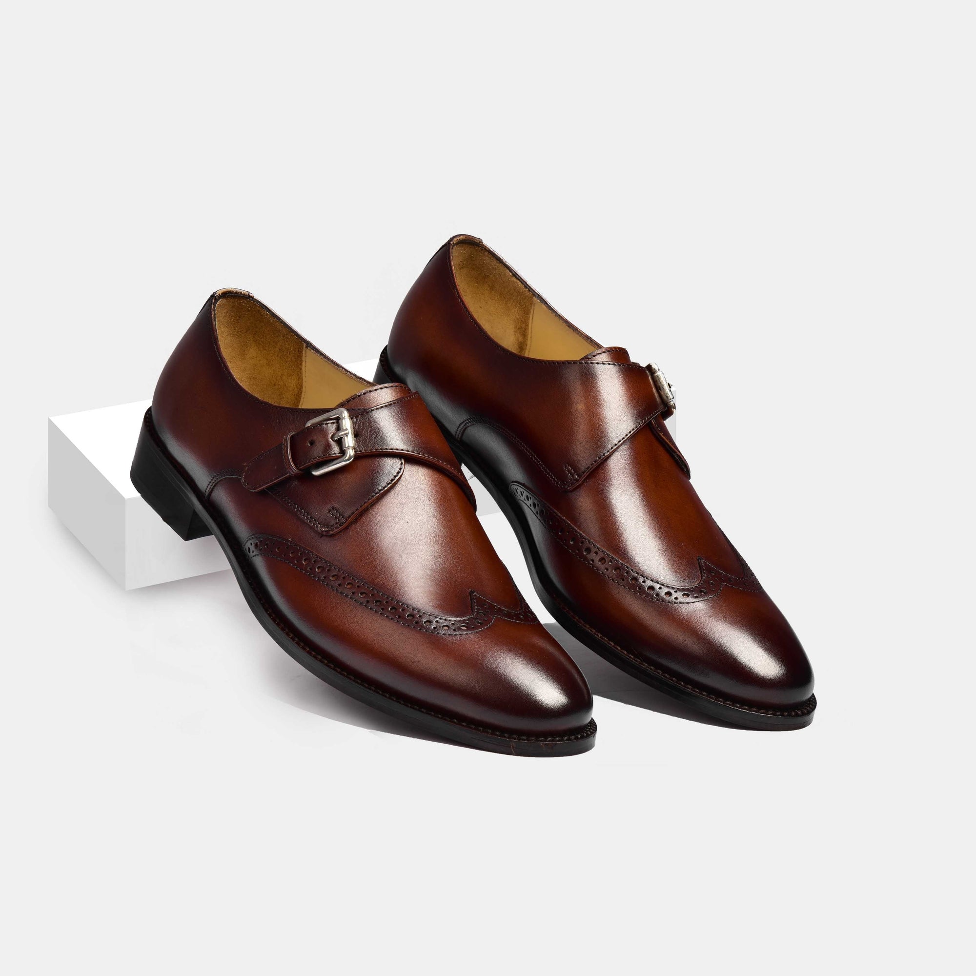 Pair of Steward Brown Single Leather Monk Strap shoes with brogue detailing on a white background.