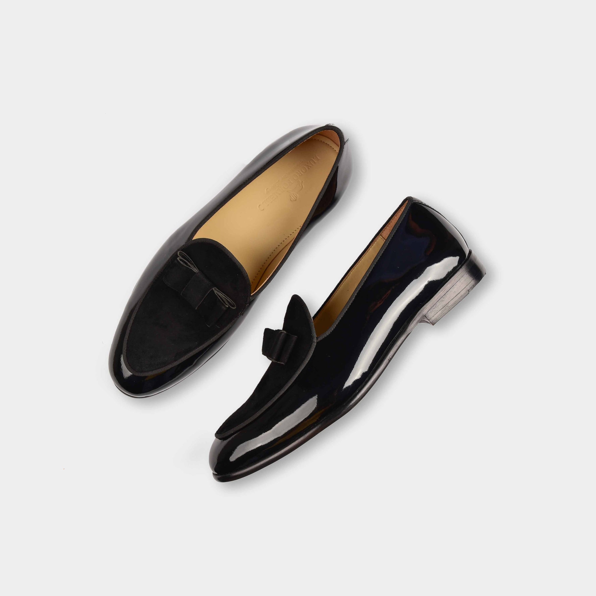 Pair of Arno loafers in black patent calf leather with a suede bow-tie detail.