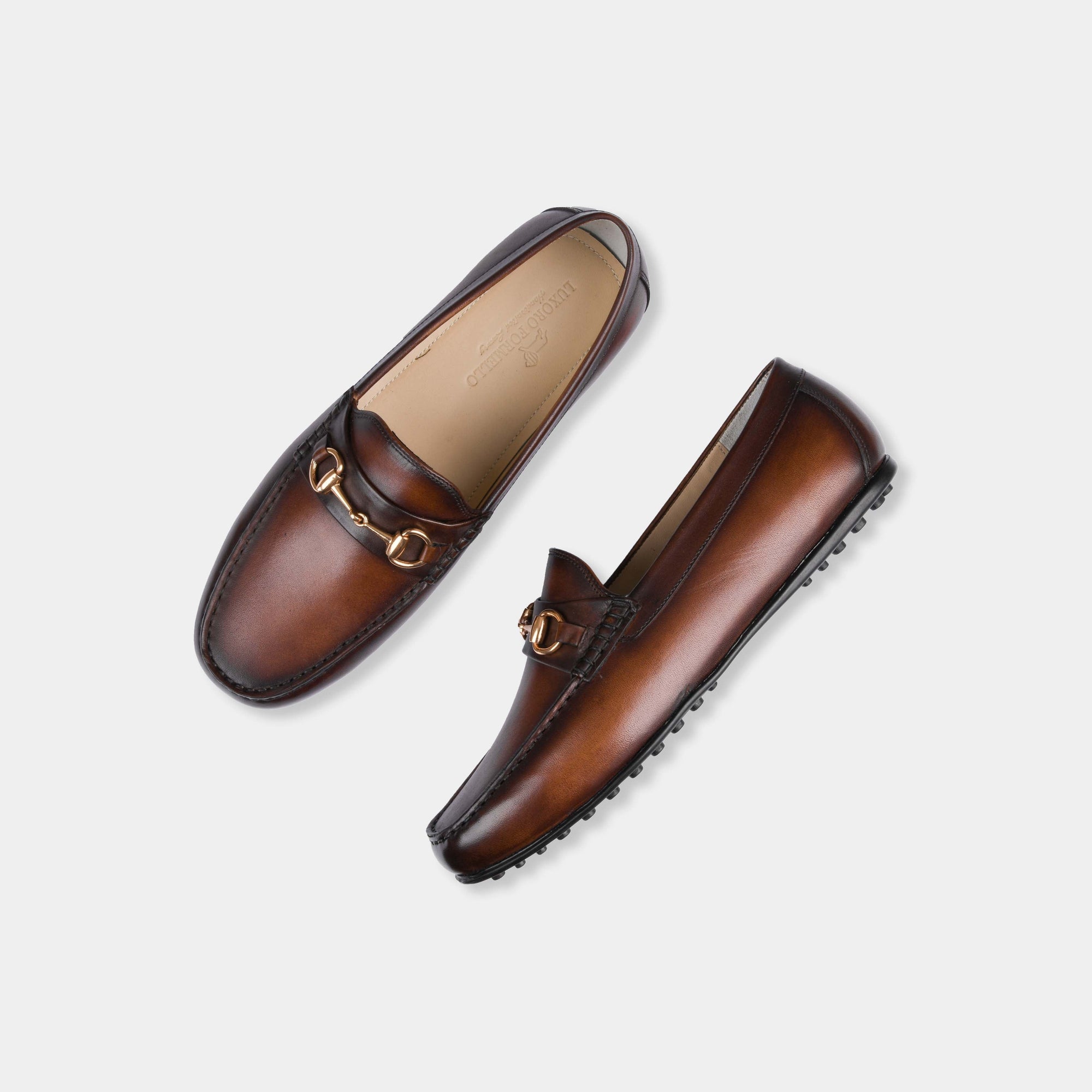 Pair of Maceo Cognac Leather Driving Loafers with gold buckle detail, shown from above.