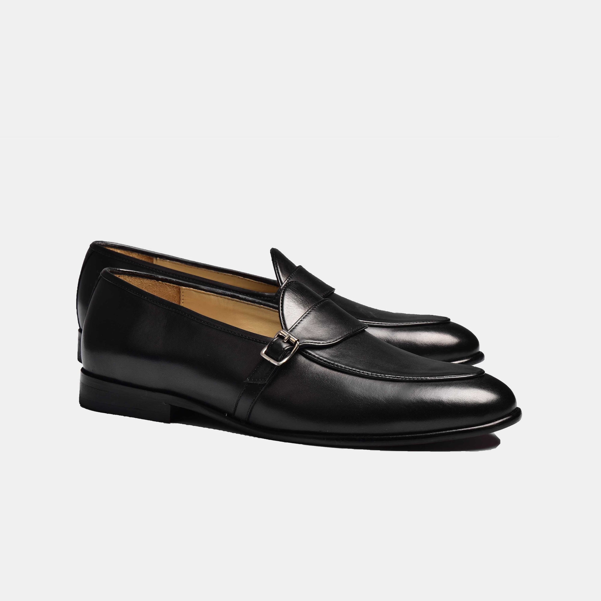 Pair of black patina Arno Loafers with a single strap buckle closure.