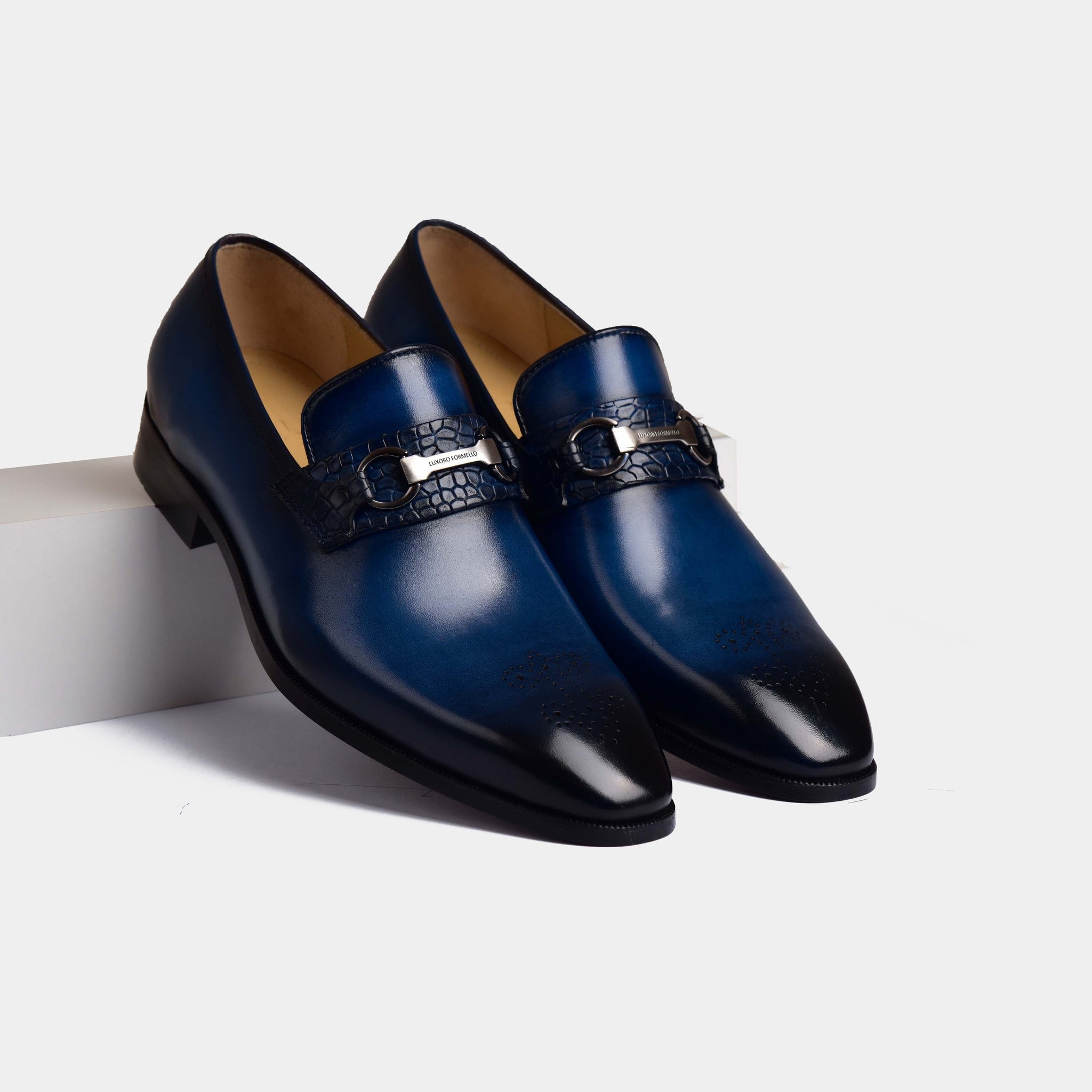 A pair of Maurici Blue Loafers in navy blue leather with a stylish crocodile-embossed strap and buckle detail.