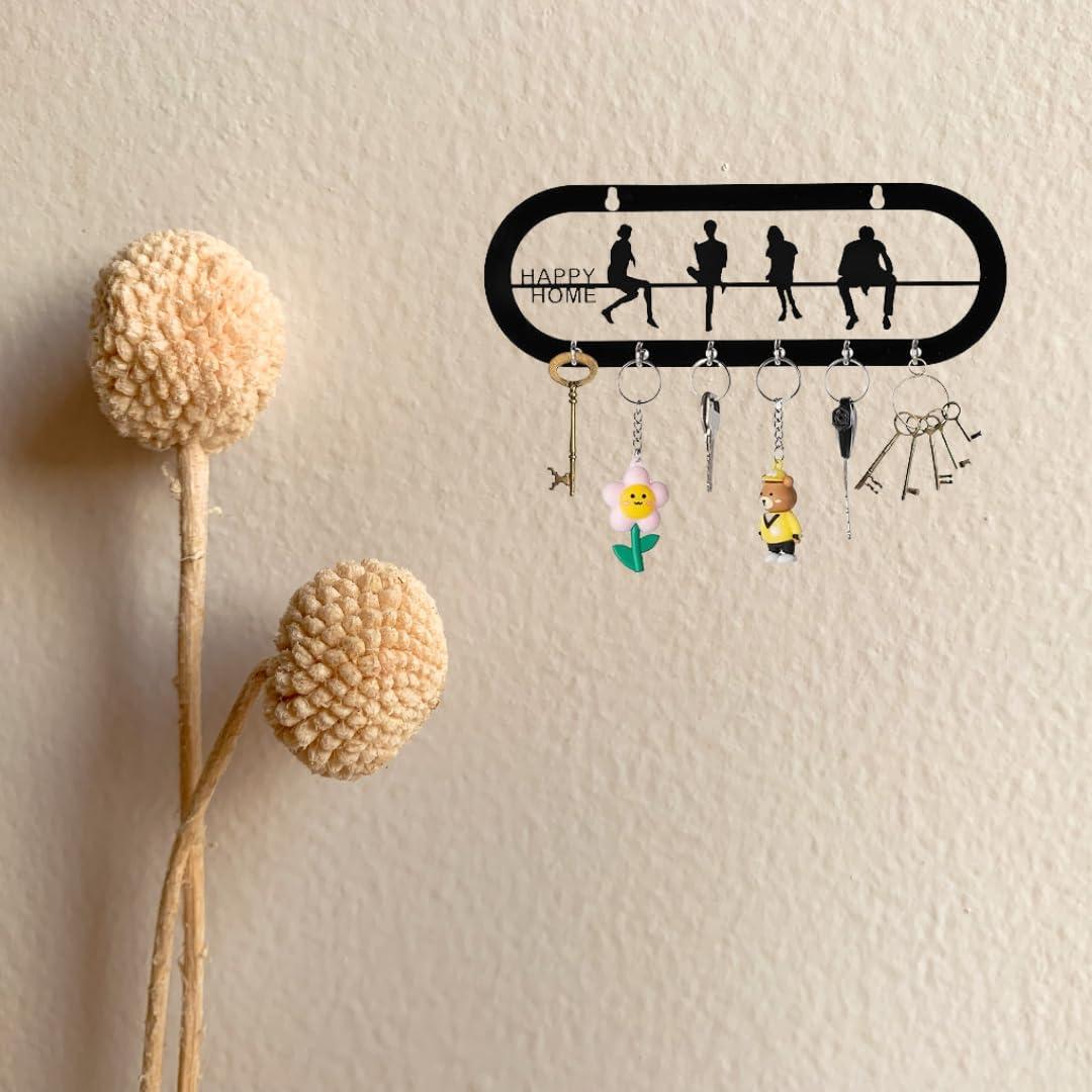 Black metal key holder for wall with "Happy Home" inscription, featuring six hooks holding keys and keychains.