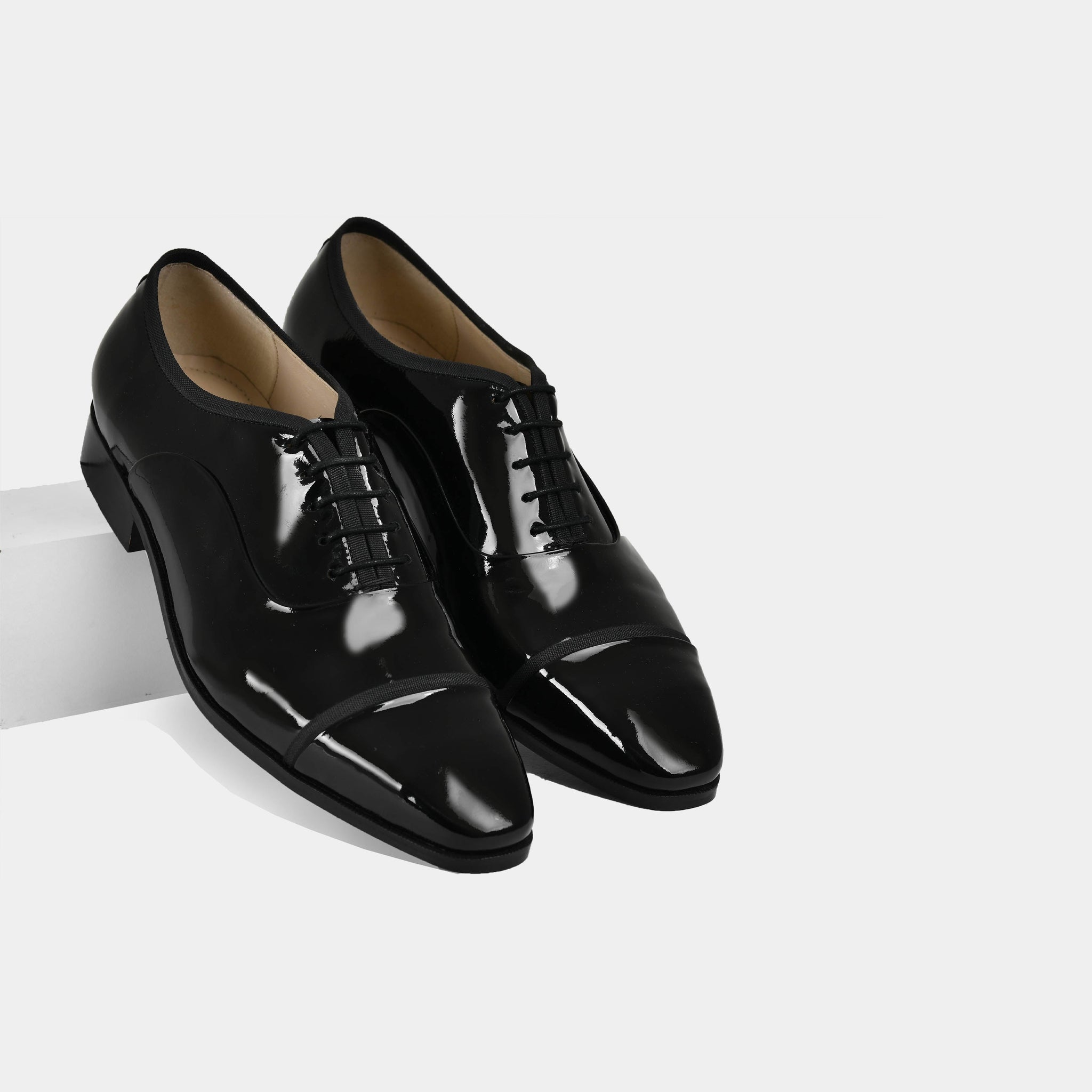 Pair of black Lsandro Patent Leather Laceups with a cap toe design.