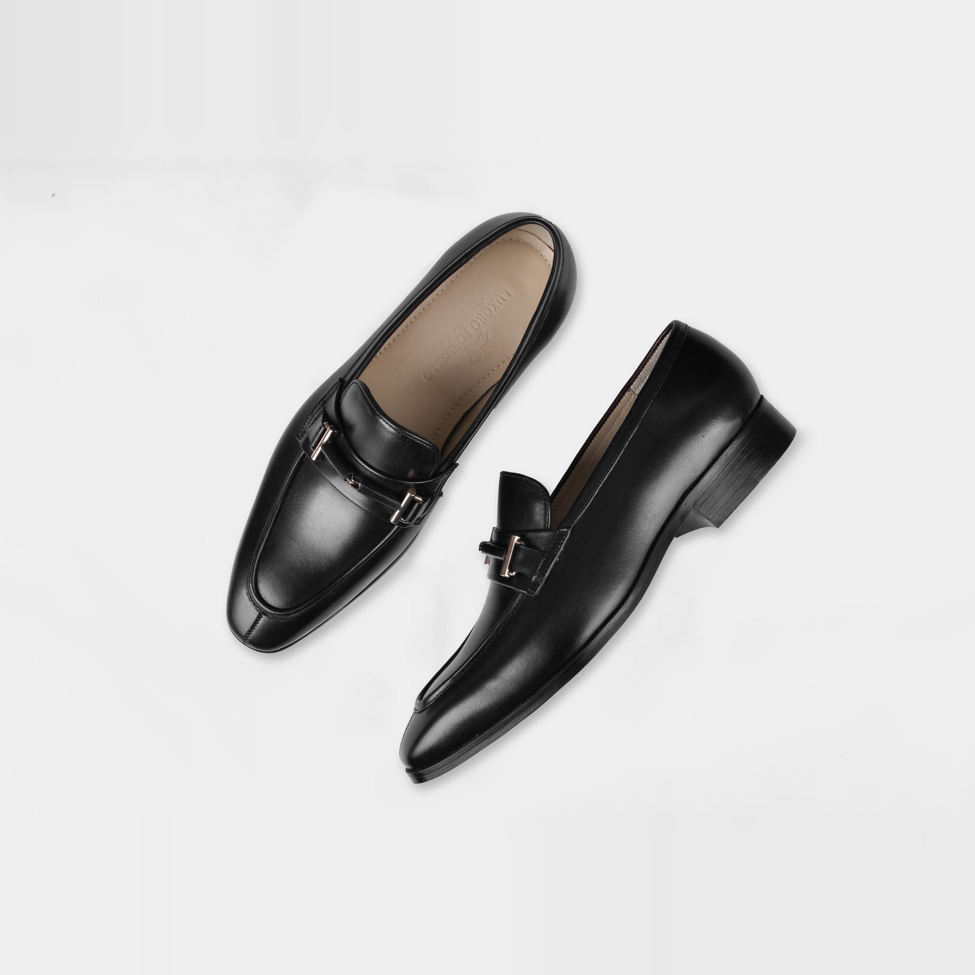 Pair of Adelmo Black Leather Loafers with a metal buckle accent, styled on a white background.