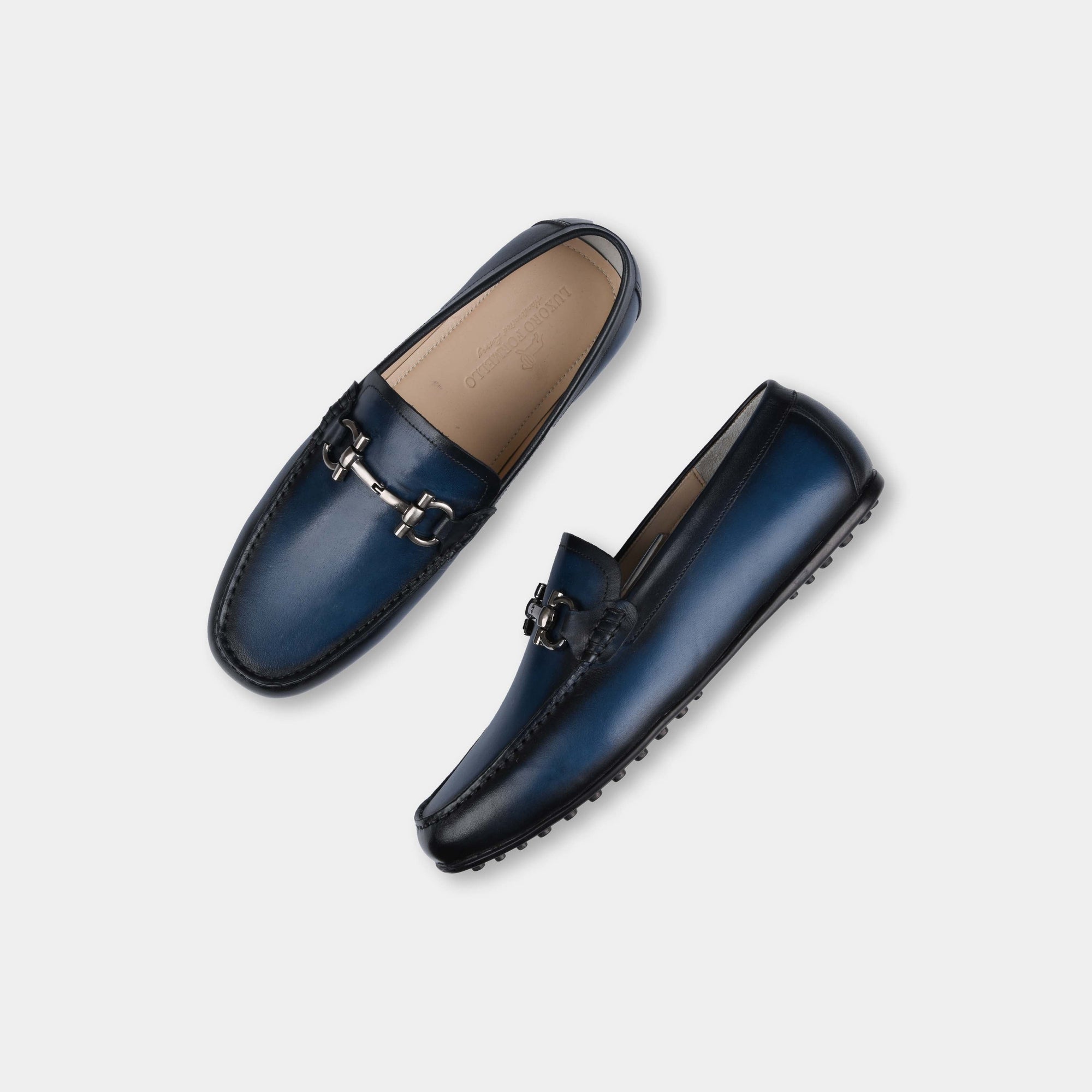 A pair of Helio Blue Leather Driving Loafers with a silver buckle detail.