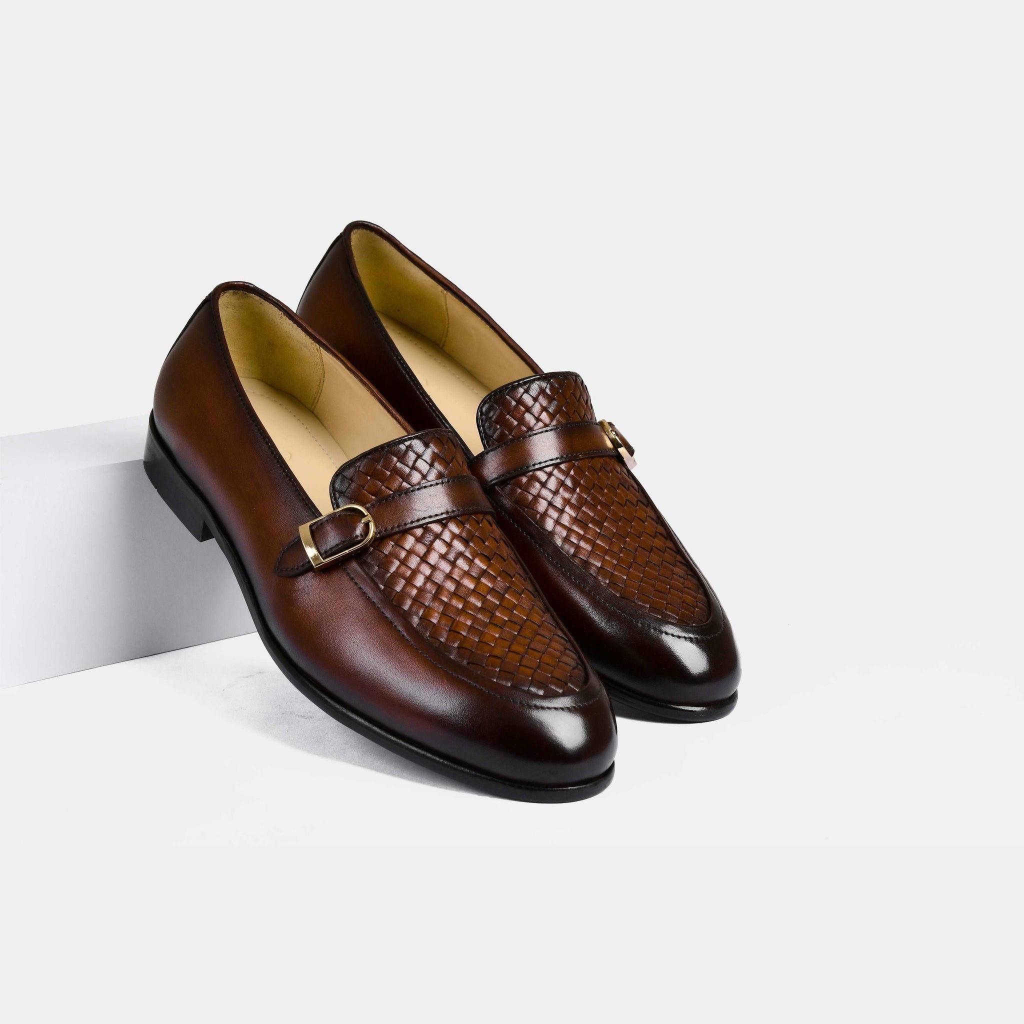 A pair of Arlow Brown Weaved Buckle Leather Loafers on a white background.