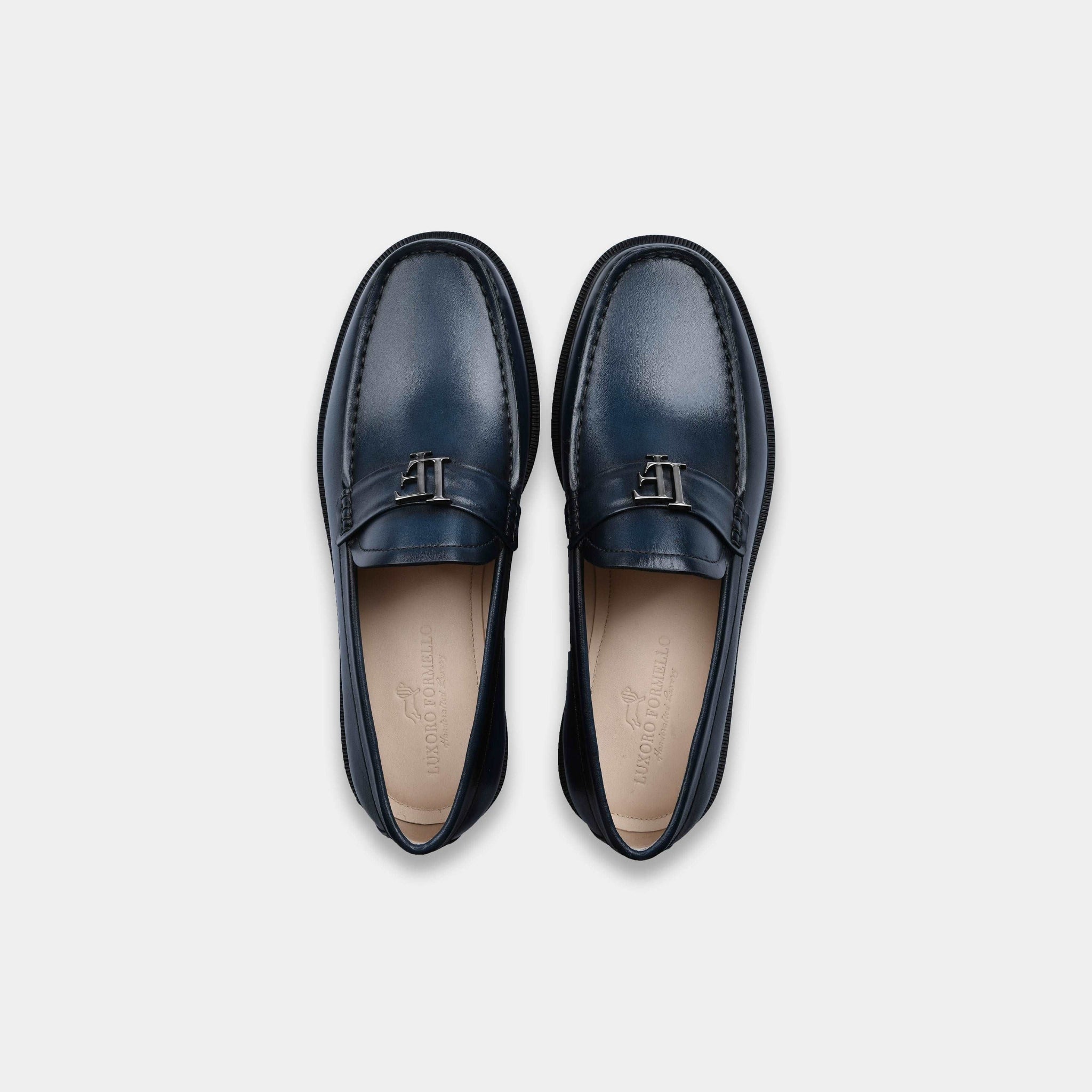 Pair of navy blue leather loafers with silver buckle detail, shown from above on a white background.