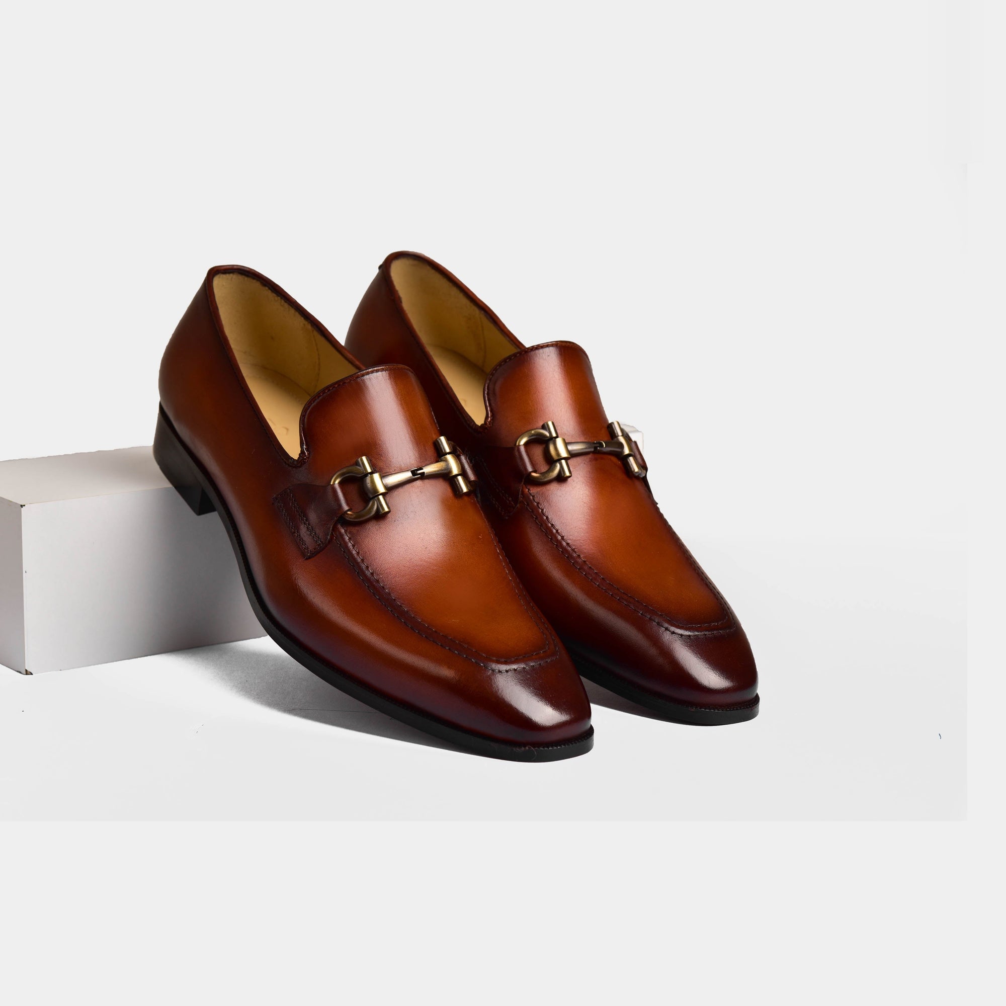 A pair of Dario Tan Leather Loafers with a gold buckle detail.