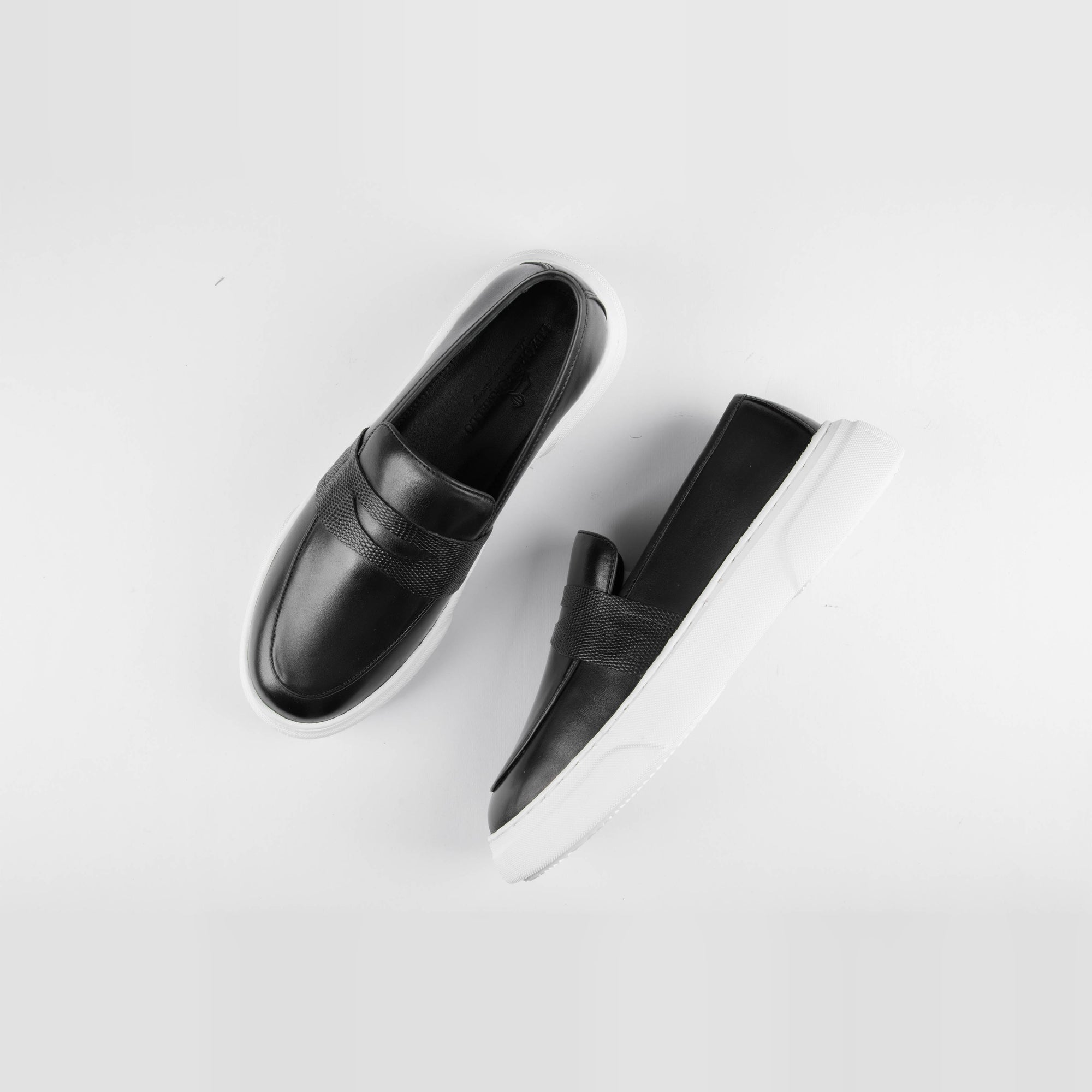 Pair of Saul Black Leather Sneakers with white soles, shown from above on a white background.