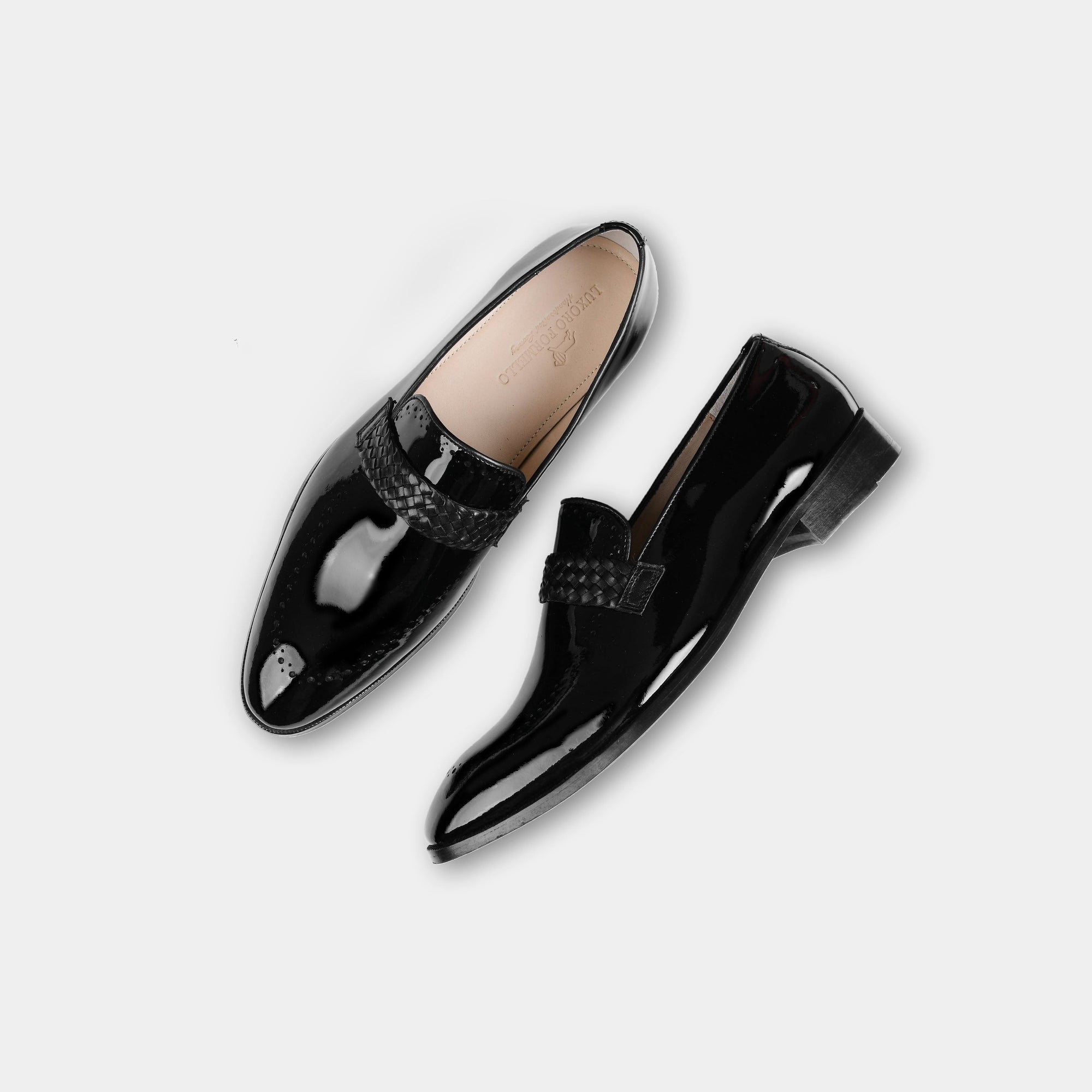 Pair of black Atilio Patent Leather Loafers with a woven strap detail, shown from above on a white background.