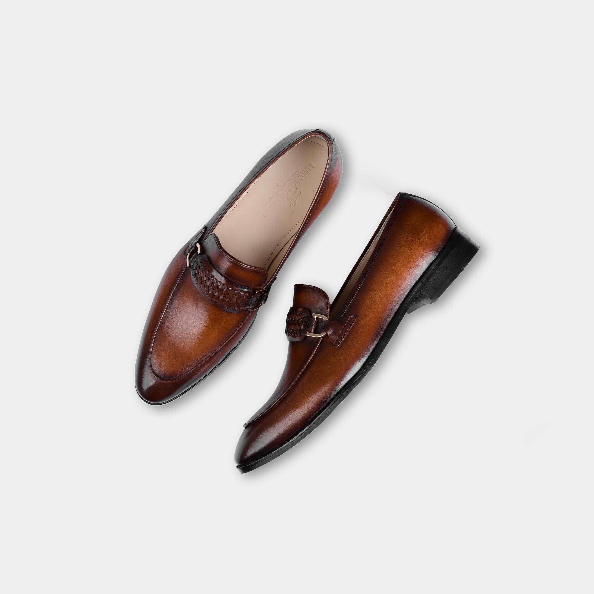 Pair of Cesar Cognac Leather Loafers, brown leather loafers with a woven strap and gold buckle detail.