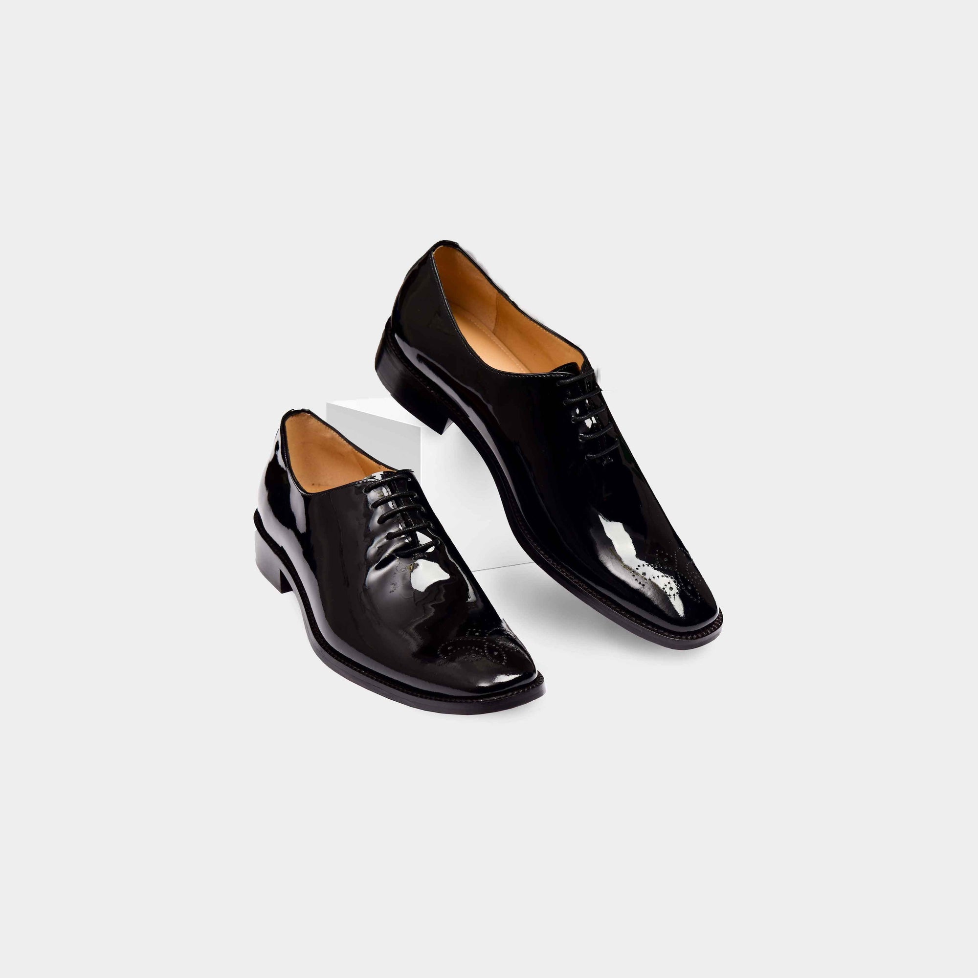 Pair of Oscar Noir Lace Ups, black patent leather dress shoes with brogue detailing.