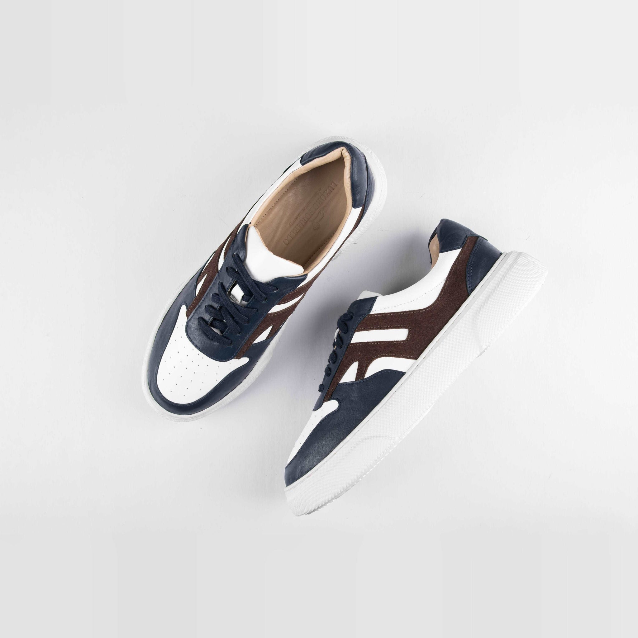 Pair of Classic Luxoro LF leather sneakers in white, navy blue, and brown leather, styled from above on a white background.