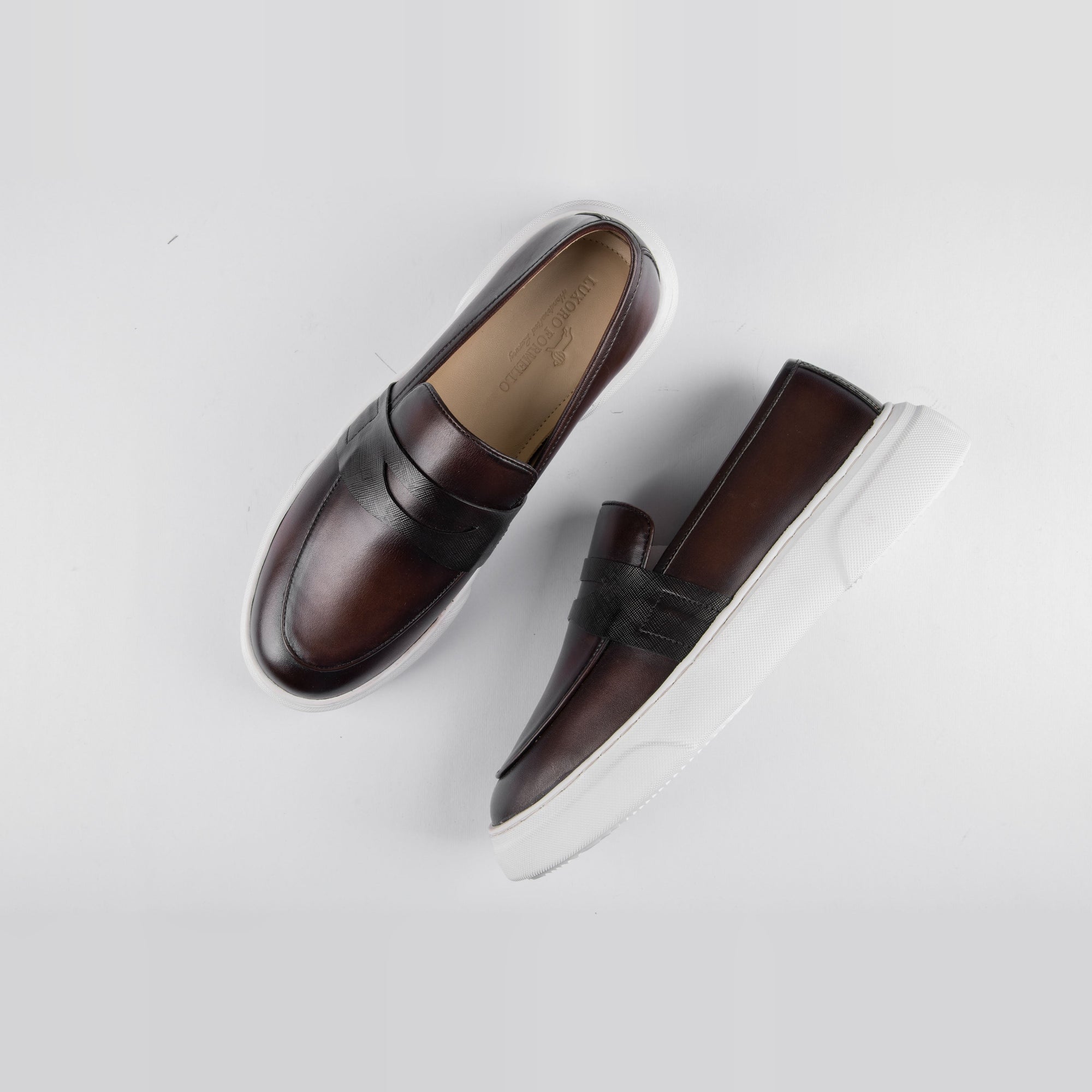 Pair of Saul Brown Leather Sneakers with a penny loafer style and white rubber soles.