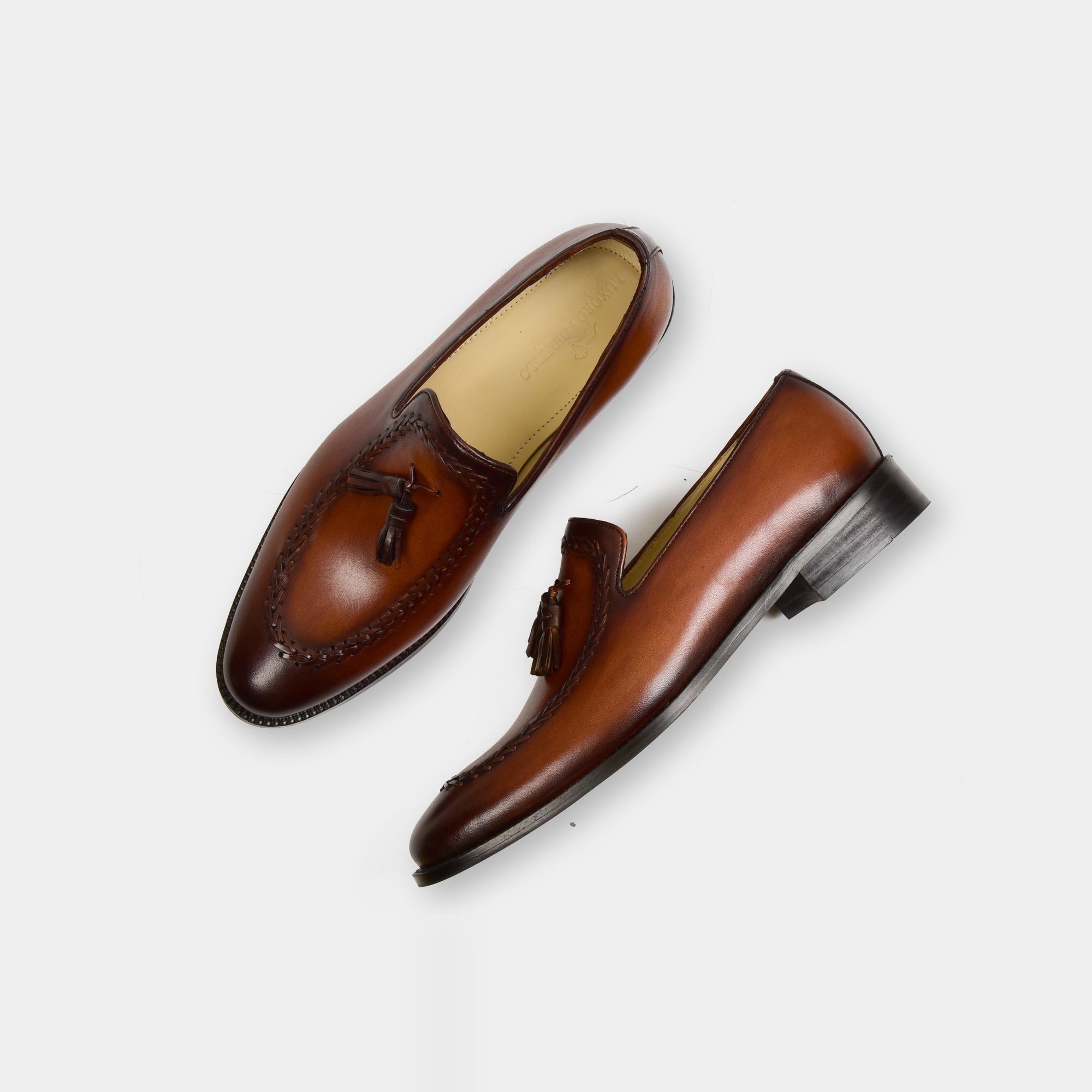 A pair of Peter Norwan Leather Loafers in brown, showcasing the stylish tassel detail and intricate stitching.