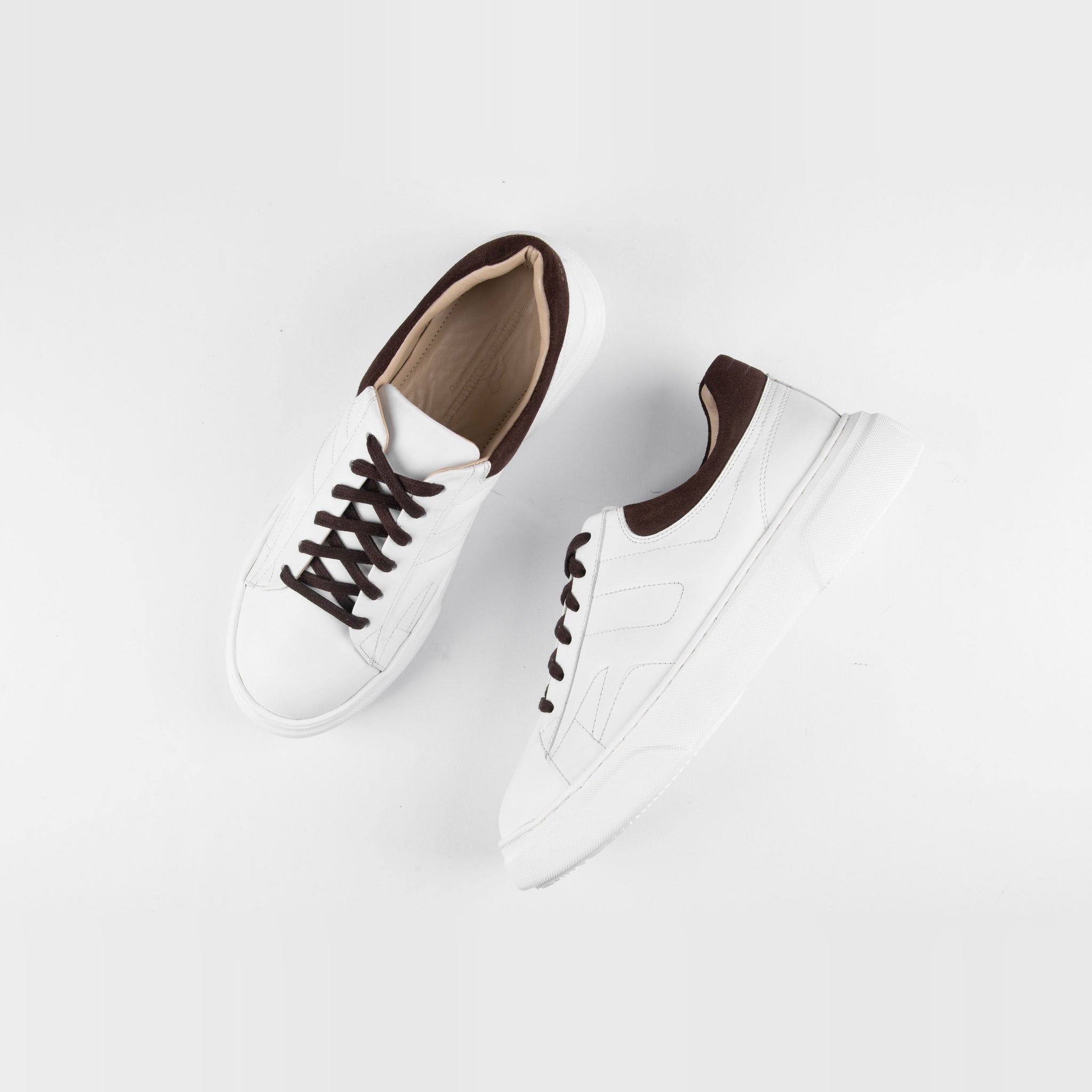 Pair of white lace-up sneakers for men with brown accents, styled on a white background.