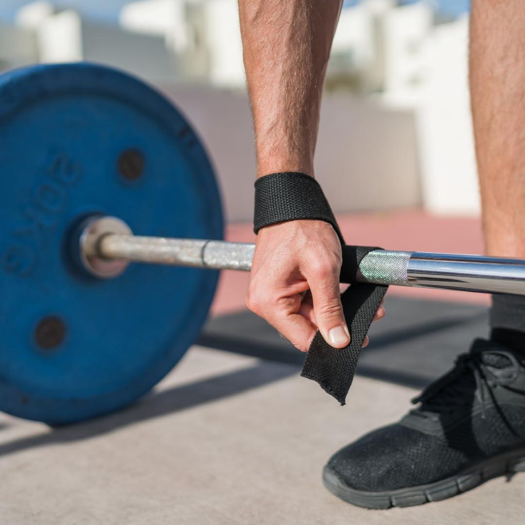 Close-up of weightlifter securing black lifting straps before lifting a barbell. These straps provide enhanced grip and wrist support for improved weightlifting performance.